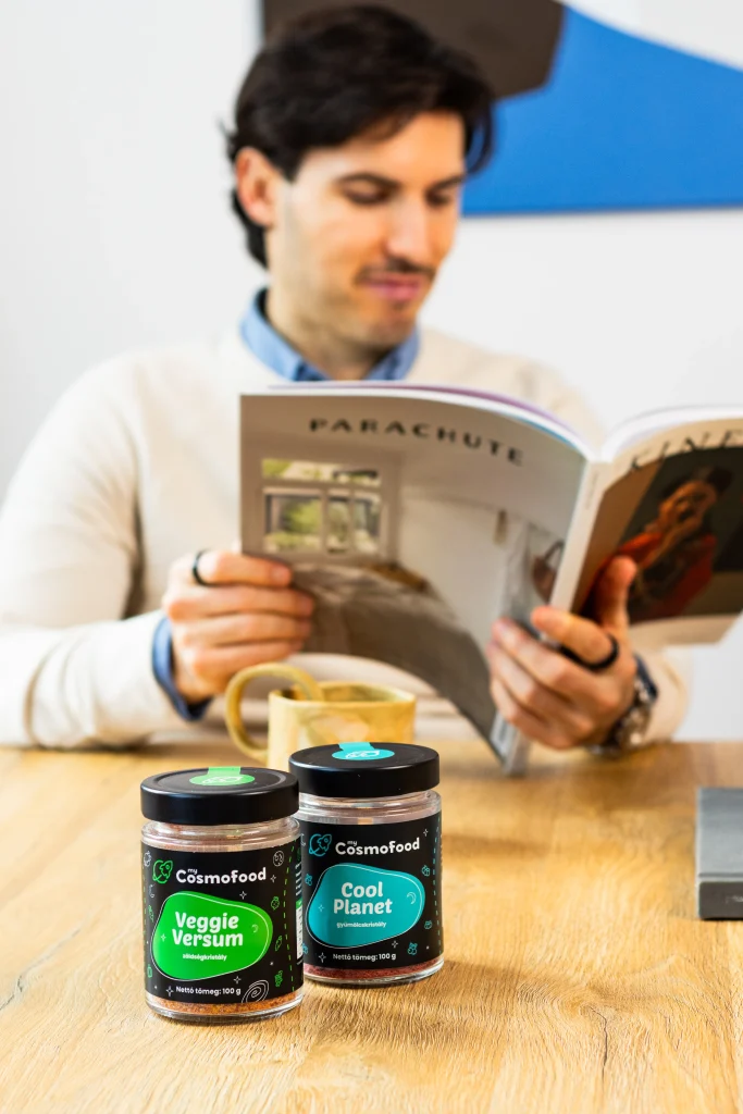 myCosmofood Veggie Versum és Cool Planet üvegek asztalon, háttérben magazint olvasó férfival