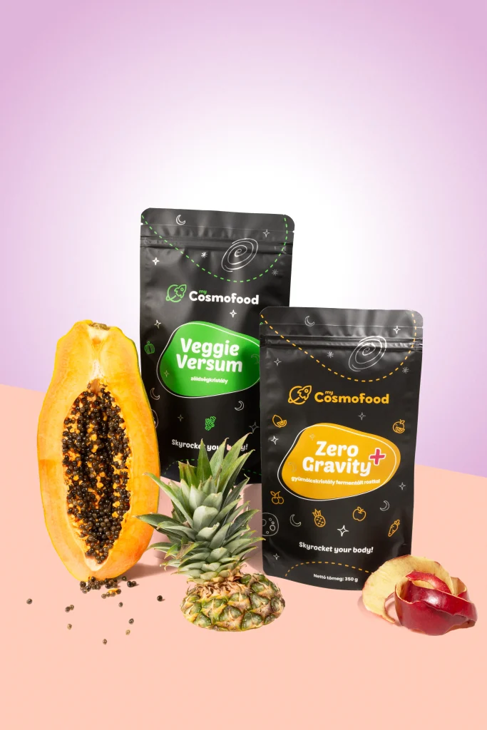 Veggie Versum és Zero Gravity+ termékcsomagolások papajával, ananásszal és almával, színes kreatív környezetben.
